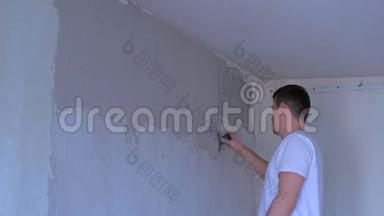 抹灰工人用腻子粉刷墙面，用抹子对齐墙面。